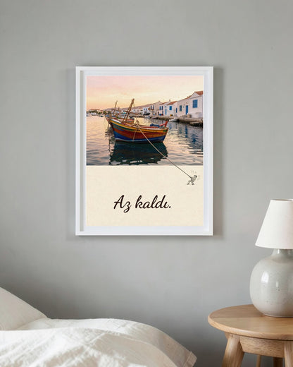 Beyaz çerçeveli Az kaldı posteri, yatak odasında yatağın ve lambalı komodinin yanındaki gri duvarda
