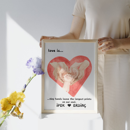 Bir bebeğin elini tutan yetişkin elleri ve "Tiny hands leave largest prints" yazılı poster detay çekimi