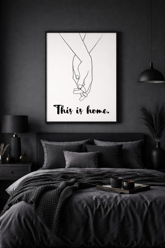 Modern bir yatak odasında yatak başı üzerinde sergilenen "This is Home" çerçeveli tablo dekorasyonu.
